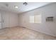 Bright room with white walls, tiled floors, a large window, and direct access to outside at 3423 W Bloomfield Rd, Phoenix, AZ 85029