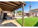 Inviting backyard oasis with covered patio, artificial turf, rock details, and mature palm trees at 3619 N 104Th Dr, Avondale, AZ 85392