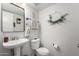Cozy powder room featuring a pedestal sink, decorative wreath, and tasteful neutral decor at 3619 N 104Th Dr, Avondale, AZ 85392
