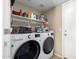Bright laundry room features side-by-side washer and dryer and ample shelf storage for supplies at 3619 N 104Th Dr, Avondale, AZ 85392