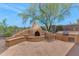 Backyard featuring a stone patio with built in grill and a custom stone pizza oven at 42122 N Anthem Springs Rd, Anthem, AZ 85086