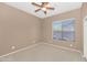 Neutral bedroom with ceiling fan and natural light through a large window at 42122 N Anthem Springs Rd, Anthem, AZ 85086