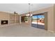 Spacious living room featuring fireplace, built-in shelving, and large sliding glass doors to outdoor living area at 42122 N Anthem Springs Rd, Anthem, AZ 85086