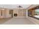 Spacious living room with a cozy fireplace, built-in shelving, neutral colors, and bright windows at 42122 N Anthem Springs Rd, Anthem, AZ 85086