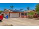 Single-story home with a two-car garage, solar panels, and desert landscaping at 4501 N 60Th Ave, Phoenix, AZ 85033