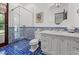 Modern bathroom with glass shower, blue tiled accents, and stylish vanity at 5225 N 23Rd St, Phoenix, AZ 85016