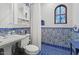 Elegant bathroom with blue tiled accents, stained-glass window, and stylish vanity at 5225 N 23Rd St, Phoenix, AZ 85016