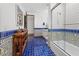 Bright bathroom with blue tile floors, shower with glass door, and wooden storage at 5225 N 23Rd St, Phoenix, AZ 85016