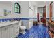 Charming bathroom with blue tile flooring, decorative accents, and stained-glass window at 5225 N 23Rd St, Phoenix, AZ 85016