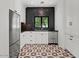 Modern kitchen with white cabinets, stainless steel appliances, black backsplash, and decorative patterned flooring at 5225 N 23Rd St, Phoenix, AZ 85016