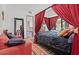 Cozy bedroom with draped canopy bed, colorful bedding, and a view into the luxurious bathroom at 5225 N 23Rd St, Phoenix, AZ 85016