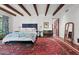Charming main bedroom featuring exposed wood beams, a tufted headboard and large decorative rug at 5225 N 23Rd St, Phoenix, AZ 85016
