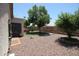The backyard features a stone landscape and a lush tree providing shade at 5437 W Bluefield Ave, Glendale, AZ 85308