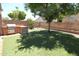 Backyard featuring artificial turf, mature landscaping, a BBQ, and block fence at 5437 W Bluefield Ave, Glendale, AZ 85308