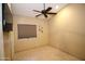 Bedroom with tan walls features ceiling fan, window with shade, sconces and neutral tile flooring at 5437 W Bluefield Ave, Glendale, AZ 85308