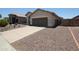 View of a single-story home with a two-car garage and a gravel front yard at 5437 W Bluefield Ave, Glendale, AZ 85308