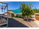 A spacious backyard featuring a garden, shed, mature tree, and shade sail for comfortable outdoor living at 557 S Lemon Ct, Gilbert, AZ 85296