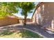 A spacious backyard offering a serene and private outdoor space with mature tree and hardscape design elements at 557 S Lemon Ct, Gilbert, AZ 85296