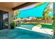 Covered patio with outdoor grill overlooks a lush green lawn and a fenced yard perfect for relaxation and entertainment at 557 S Lemon Ct, Gilbert, AZ 85296