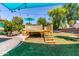 Inviting backyard with a wooden deck, shade sail, lush lawn, offering a great space for outdoor activities at 557 S Lemon Ct, Gilbert, AZ 85296