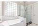 Main bathroom features tile surround, walk-in shower and soaking tub with lots of natural light at 557 S Lemon Ct, Gilbert, AZ 85296
