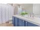 Bathroom featuring double sinks, blue cabinets, and a shower with curtain at 557 S Lemon Ct, Gilbert, AZ 85296