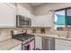 Kitchen with stainless appliances, granite counters, tile backsplash and white cabinets at 557 S Lemon Ct, Gilbert, AZ 85296
