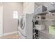 Bright laundry room featuring a modern washer and dryer set with built-in storage shelving for optimal organization at 557 S Lemon Ct, Gilbert, AZ 85296