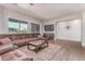 Spacious living room with hardwood floors, large sectional, TV, and a stylish accent wall at 557 S Lemon Ct, Gilbert, AZ 85296