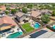 Aerial view of a landscaped backyard with a pool, patio, desert landscaping, and a desert residential community at 5744 E Jacaranda St, Mesa, AZ 85205