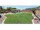 Spacious backyard offers a refreshing pool, mature trees, and green lawn at 5744 E Jacaranda St, Mesa, AZ 85205