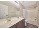 Bathroom featuring double sinks with dark wood cabinets, tub shower combination, and neutral color scheme at 5744 E Jacaranda St, Mesa, AZ 85205