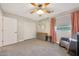 Bright bedroom with a leafy accent wall, a ceiling fan, and a comfortable rocking chair at 5744 E Jacaranda St, Mesa, AZ 85205