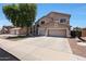 A two-story home with a three-car garage, landscaped front yard, and neutral colored paint at 5744 E Jacaranda St, Mesa, AZ 85205