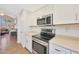 This kitchen has stainless steel appliances, white cabinets, and light countertops at 5744 E Jacaranda St, Mesa, AZ 85205