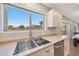 Bright kitchen features stainless steel sink, modern faucet, and window overlooking the backyard at 5744 E Jacaranda St, Mesa, AZ 85205
