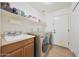 Well-organized laundry room with washer, dryer, sink, and storage shelves for convenience at 5744 E Jacaranda St, Mesa, AZ 85205
