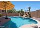 Relaxing backyard pool with a rock waterfall, lounge chairs and desert landscaping at 5744 E Jacaranda St, Mesa, AZ 85205