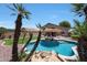 Stunning backyard pool featuring a rock waterfall, lush landscaping and lounge seating at 5744 E Jacaranda St, Mesa, AZ 85205