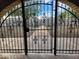 View through an arched gate to the landscaped front yard and surrounding neighborhood at 5801 N 73Rd Ave, Glendale, AZ 85303