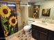 Well-lit bathroom with a sunflower shower curtain and functional vanity at 5801 N 73Rd Ave, Glendale, AZ 85303