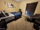Cozy bedroom with carpet flooring, ample lighting, and comfortable seating area at 5801 N 73Rd Ave, Glendale, AZ 85303