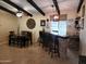 Casual dining area with brick bar, wood table and chairs under beamed ceiling at 5801 N 73Rd Ave, Glendale, AZ 85303