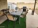 Outdoor patio area with dining table, chairs, BBQ grill, and faux grass at 5801 N 73Rd Ave, Glendale, AZ 85303