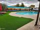Serene backyard with swimming pool, desert mural, artificial turf, and lounge chairs at 5801 N 73Rd Ave, Glendale, AZ 85303