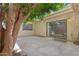 Cozy back patio with shade tree, and view through glass door to dining table at 5813 W Gelding Dr, Glendale, AZ 85306