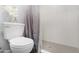 Bathroom featuring modern toilet, shower and shower curtain with neutral tones at 5813 W Gelding Dr, Glendale, AZ 85306