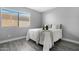 Cozy bedroom featuring a large window, neutral walls, and modern vinyl flooring at 5813 W Gelding Dr, Glendale, AZ 85306