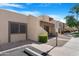 Beige home showcasing well-maintained landscaping, visitor parking, and a desert aesthetic at 5813 W Gelding Dr, Glendale, AZ 85306