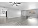 Bright living room featuring modern flooring, a ceiling fan, and a glimpse of the kitchen at 5813 W Gelding Dr, Glendale, AZ 85306